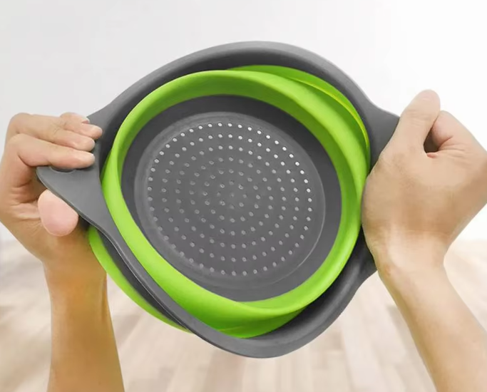 Green foldable silicone colander perfect for washing vegetables and fruits, with a space-saving collapsible design